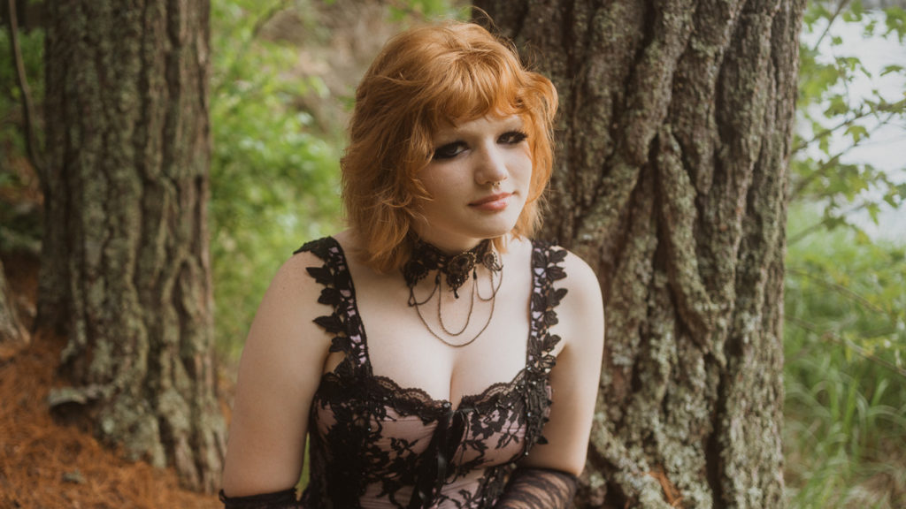 red headed senior graduation portrait session in the forest wearing a punk black and pink dress